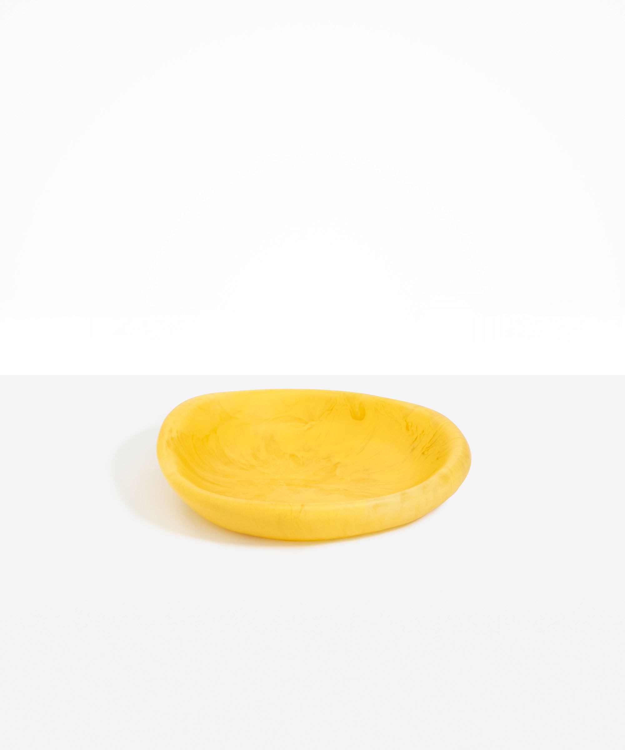 Dinosaur Designs Small Bones Bowl in Pollen — small handmade marbled yellow resin shallow serving bowl with a rounded organic form..