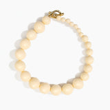 Dinosaur Designs Polished Organic Ball Choker in Cream — handcrafted cream polished resin graduating bead choker necklace with brass t-bar clasp.