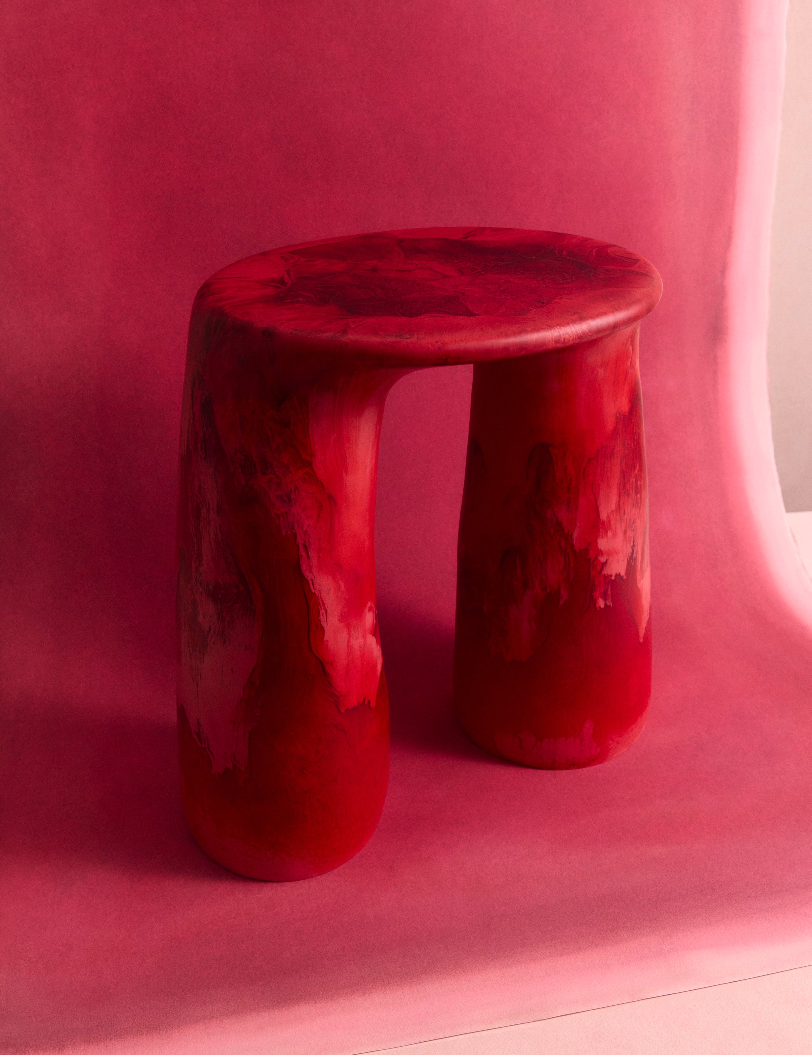Deep pink two legged resin table on a pink backdrop