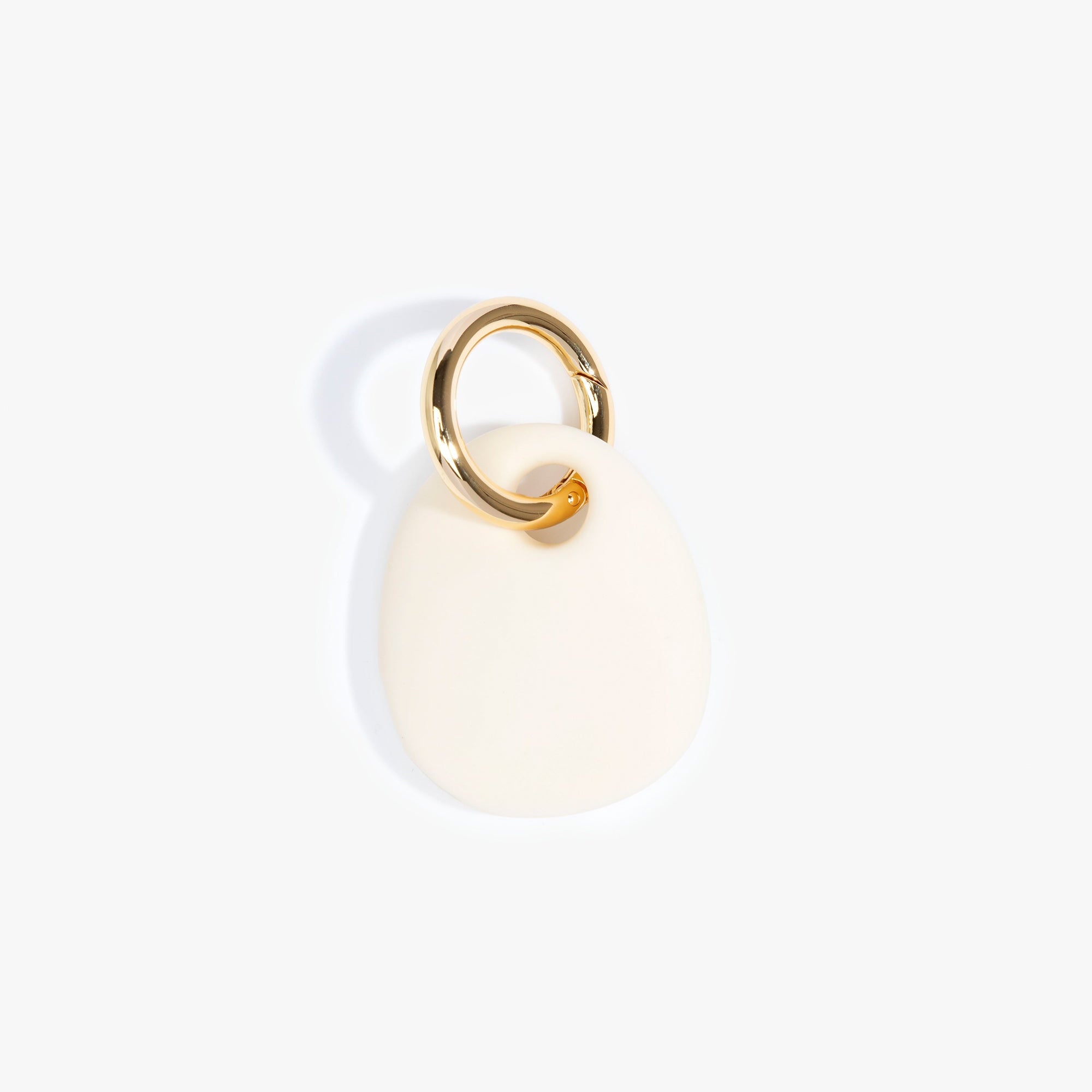 Dinosaur Designs Earth Keyring in Cream — handcrafted Cream resin pebble bead on a polished brass jump ring..