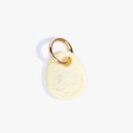 Dinosaur Designs Earth Keyring in Lemon — handcrafted marbled pastel yellow resin pebble bead on a polished brass jump ring..