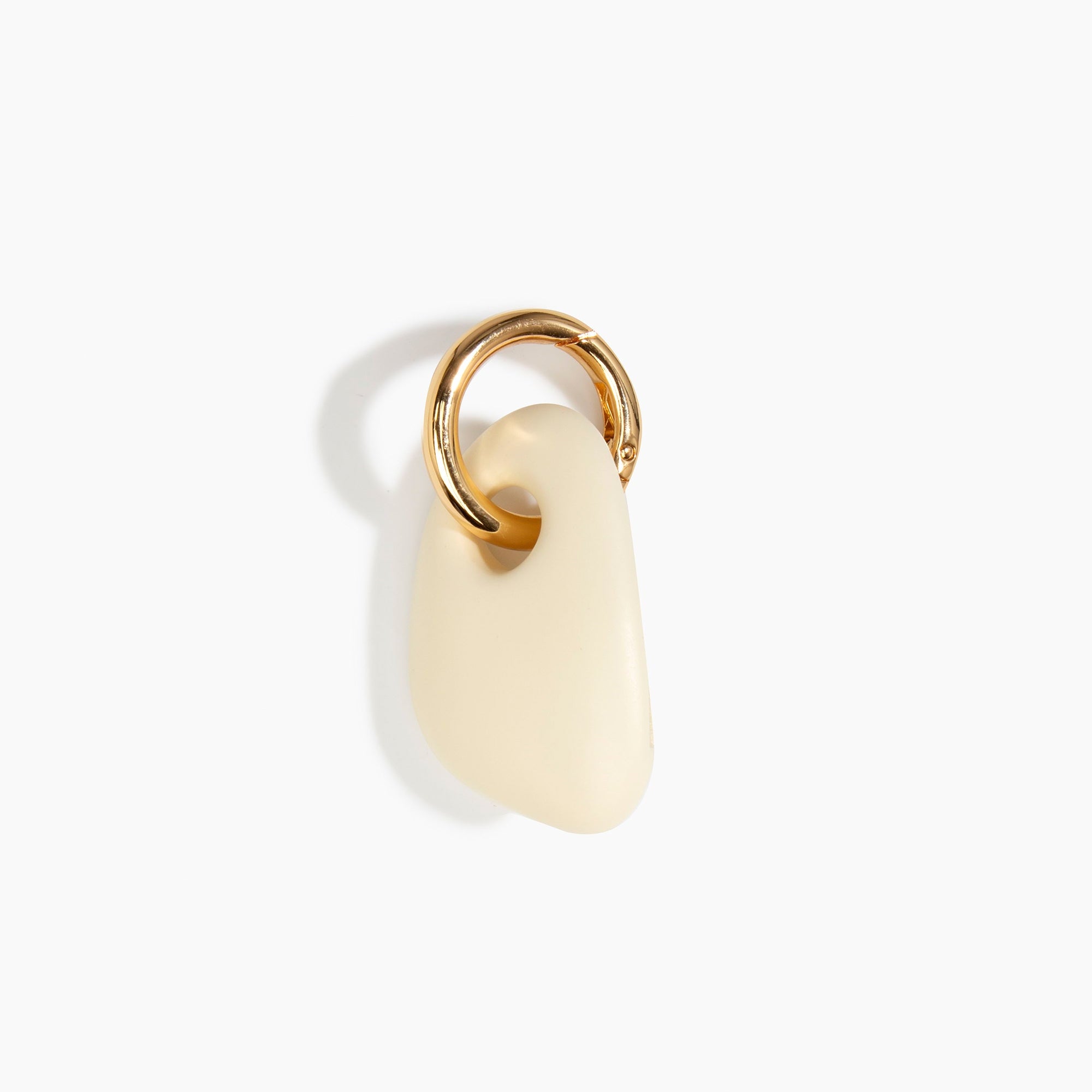 Dinosaur Designs Rock Keyring in Cream — handcrafted cream resin pebble bead on a polished brass jump ring..