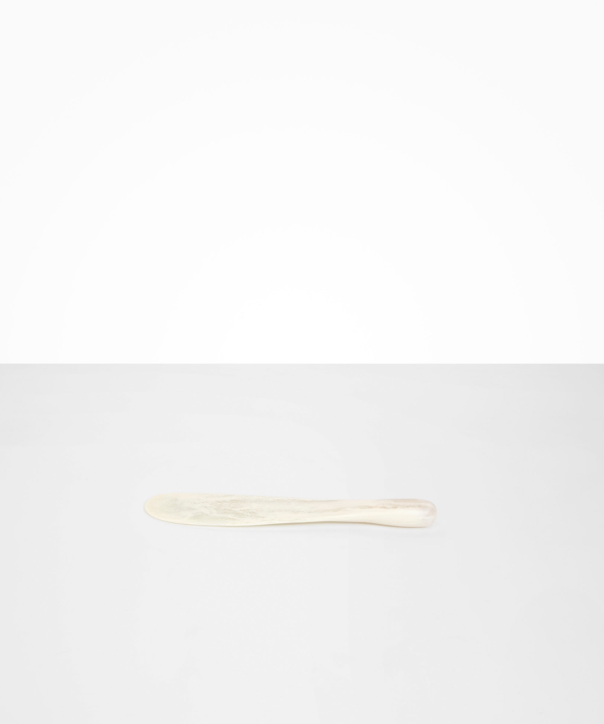 Dinosaur Designs Temple Cake Knife in Chalk Swirl — handcrafted marbled off white resin cake knife with smooth tapered blade and rounded handle.