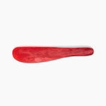 Dinosaur Designs Temple Cake Knife in Cranberry — handcrafted marbled red resin cake knife with smooth tapered blade and rounded handle.