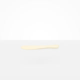 Dinosaur Designs Temple Cake Knife in Cream — handcrafted cream resin cake knife with smooth tapered blade and rounded handle.