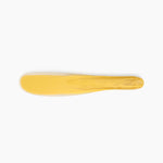 Dinosaur Designs Temple Cake Knife in Pollen — handcrafted marbled yellow and clear resin cake knife with smooth tapered blade and rounded handle.