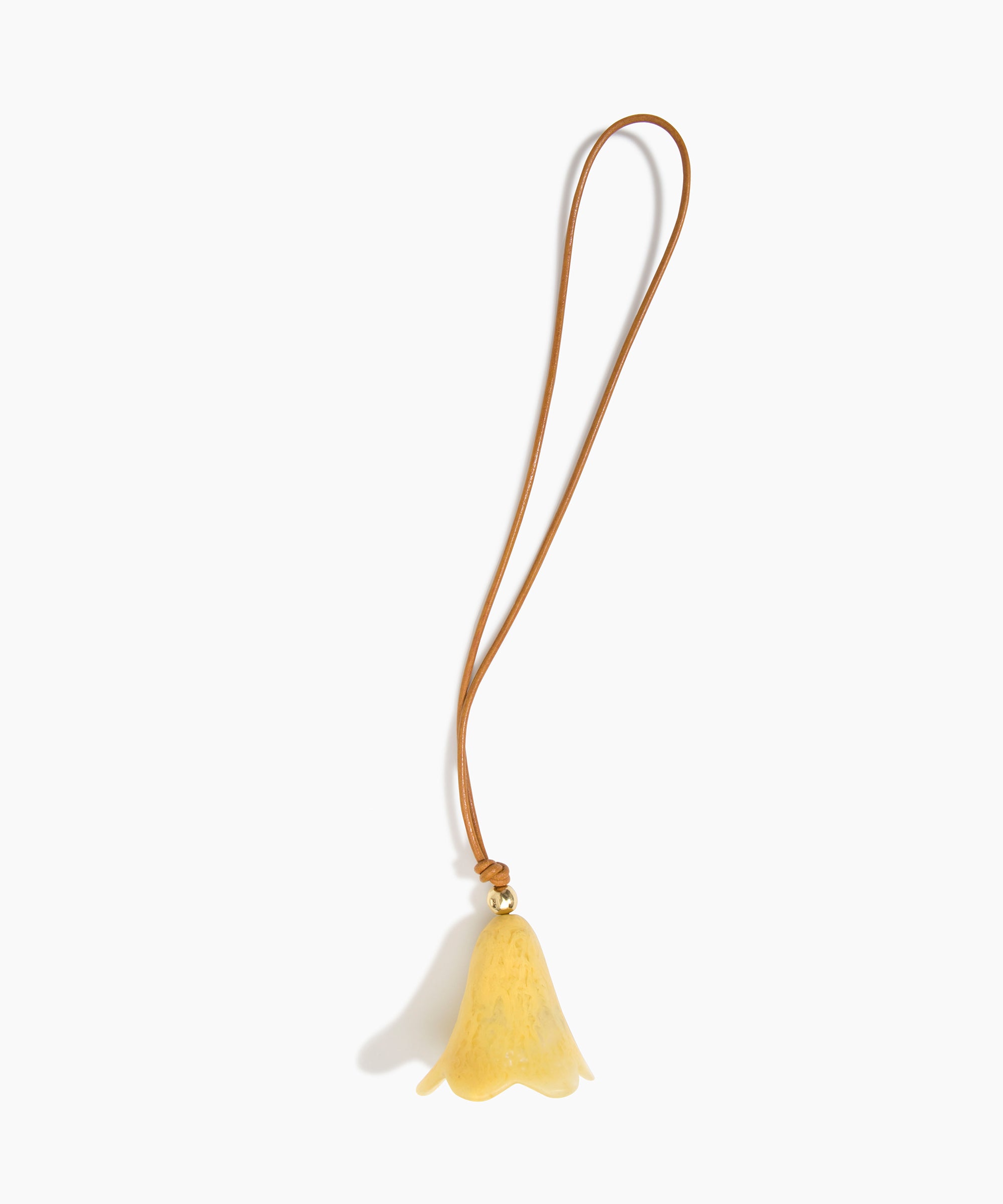 Dinosaur Designs Flower Bag Charm in Pollen colour with Brass bead — handcrafted marbled yellow resin bell-shaped flower bag charm with tan leather hanging loop and brass bead