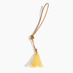 Dinosaur Designs Flower Bag Charm in Pollen colour with Brass bead — handcrafted marbled yellow resin bell-shaped flower bag charm with tan leather hanging loop and brass bead