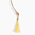Dinosaur Designs Long Flower Bag Charm in Pollen colour with Brass bead — handcrafted marbled yellow resin bell-shaped flower bag charm with tan leather hanging loop and brass bead