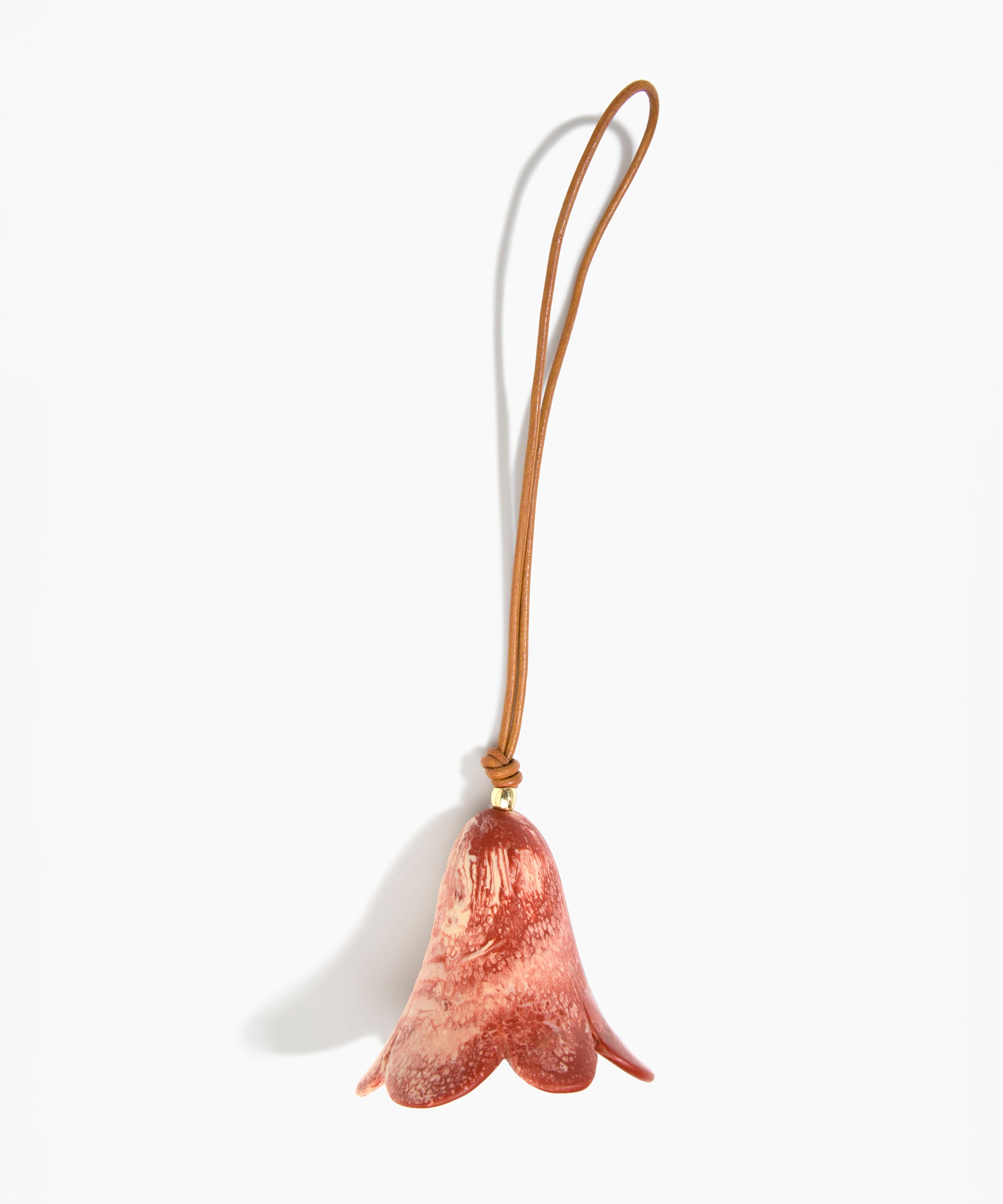 Dinosaur Designs Flower Decoration in Rust colour with Brass bead — handcrafted marbled terracotta red and cream resin bell-shaped flower ornament with tan leather hanging loop and brass bead