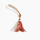 Dinosaur Designs Flower Decoration in Rust colour with Brass bead — handcrafted marbled terracotta red and cream resin bell-shaped flower ornament with tan leather hanging loop and brass bead