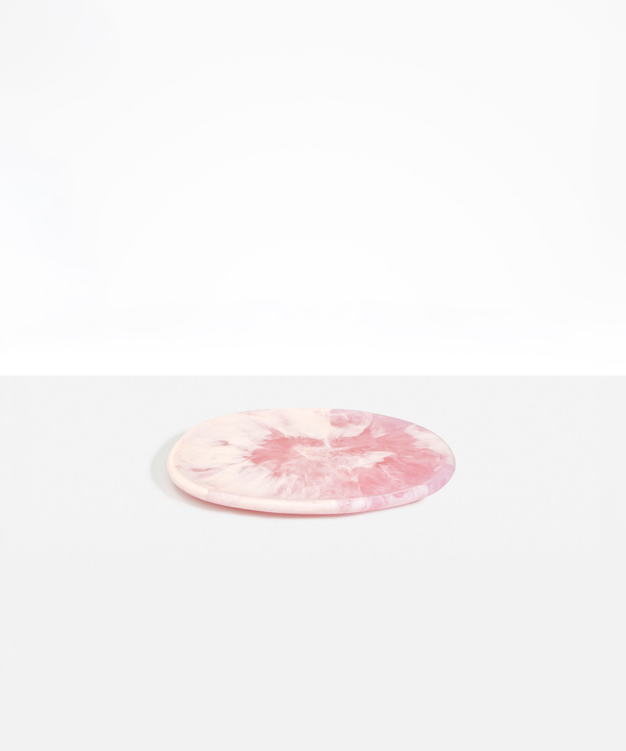 Dinosaur Designs Rock Plate in Shell Pink — handcrafted marbled pink resin oval flat serving plate with rounded organic edge..