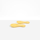 Dinosaur Designs Rock Servers in Pollen — handcrafted marbled yellow resin salad server set with rounded bulb handles, fork and spoon.