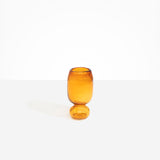 Dinosaur Designs Small Glass Rockpool Vase in Amber — handblown amber glass vase with rounded bulbous body and small spherical pedestal base..