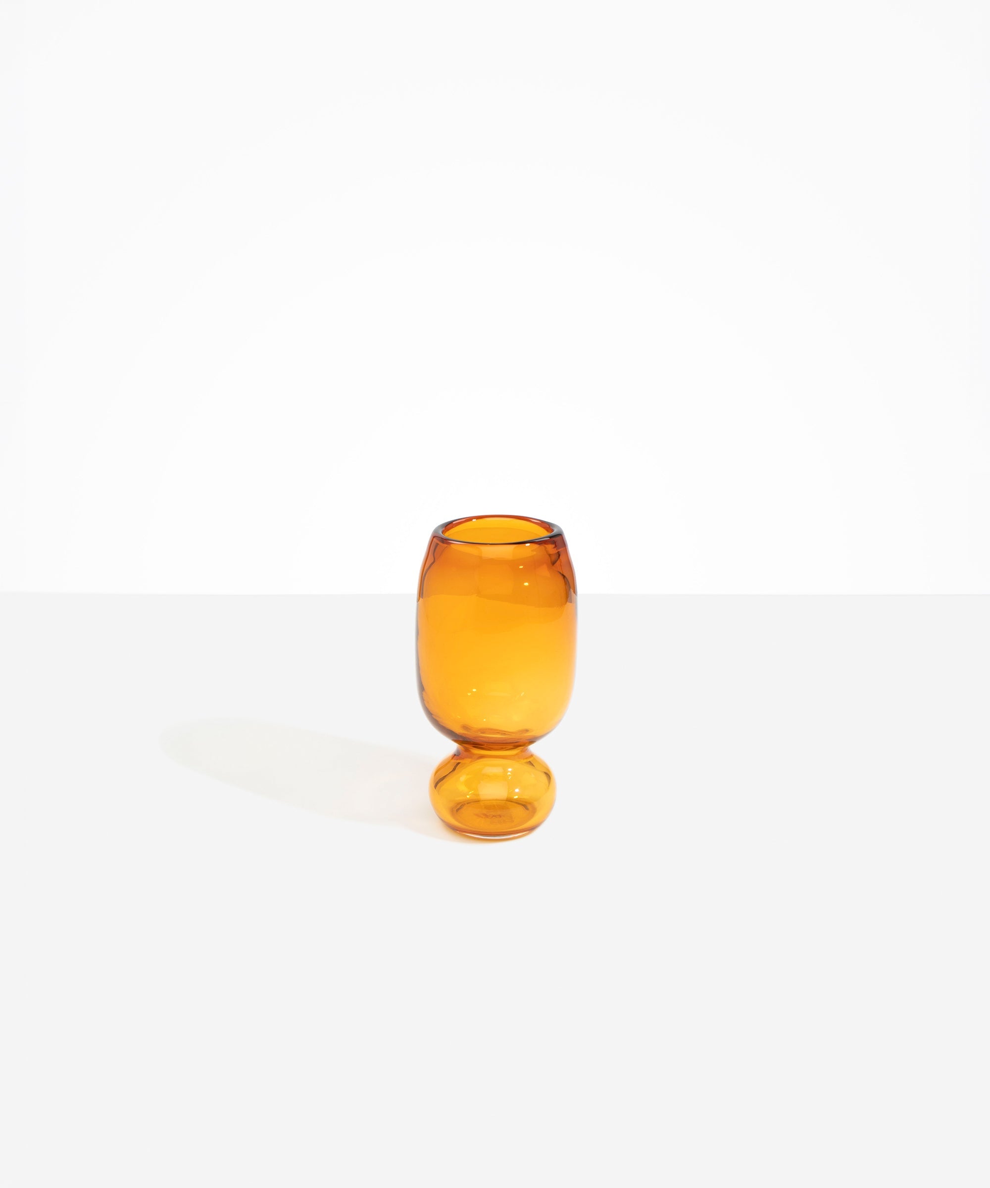 Dinosaur Designs Small Glass Rockpool Vase in Amber — handblown amber glass vase with rounded bulbous body and small spherical pedestal base..