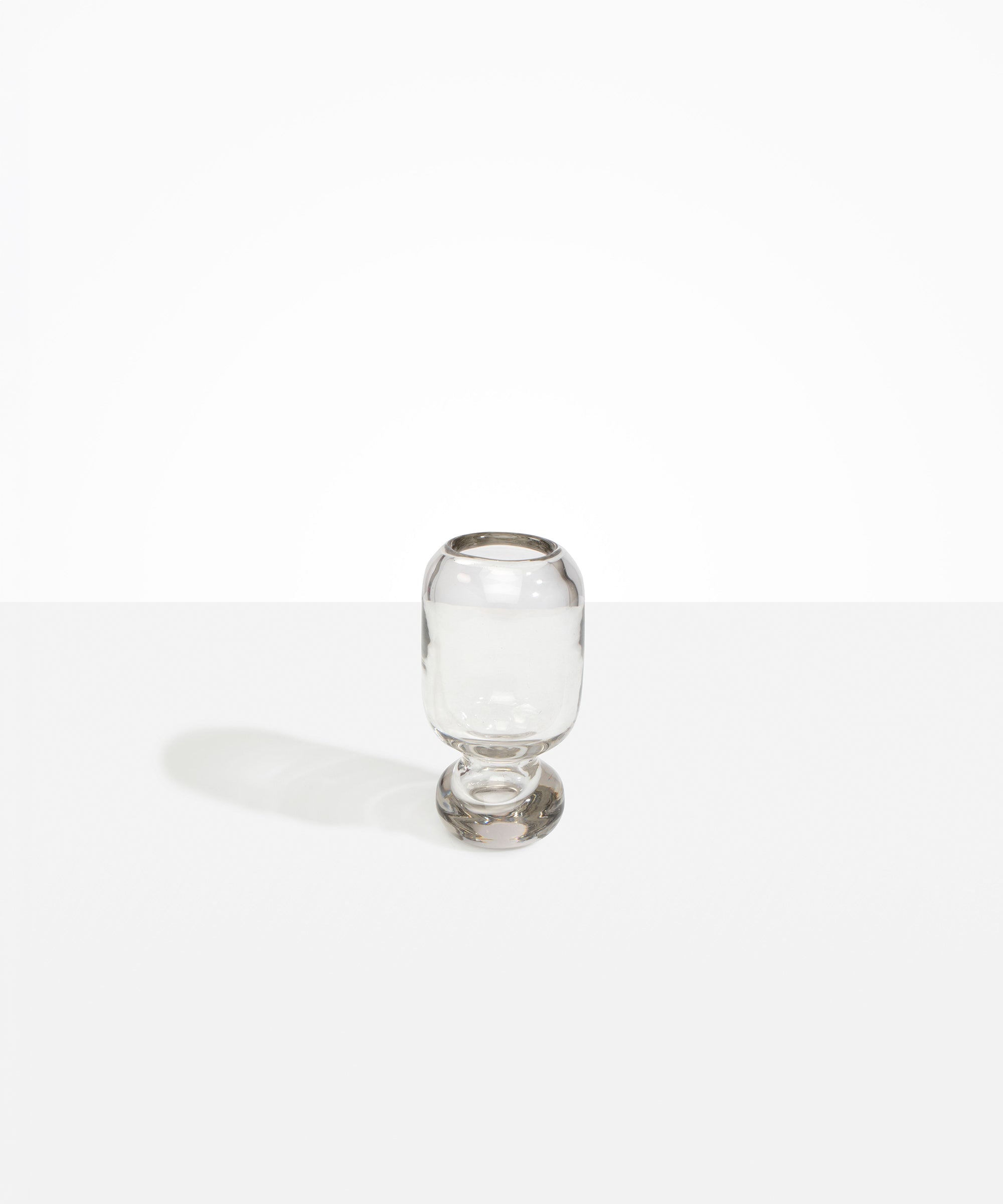 Dinosaur Designs Small Glass Rockpool Vase in Clear — handblown transparent glass vase with rounded bulbous body and small spherical pedestal base..